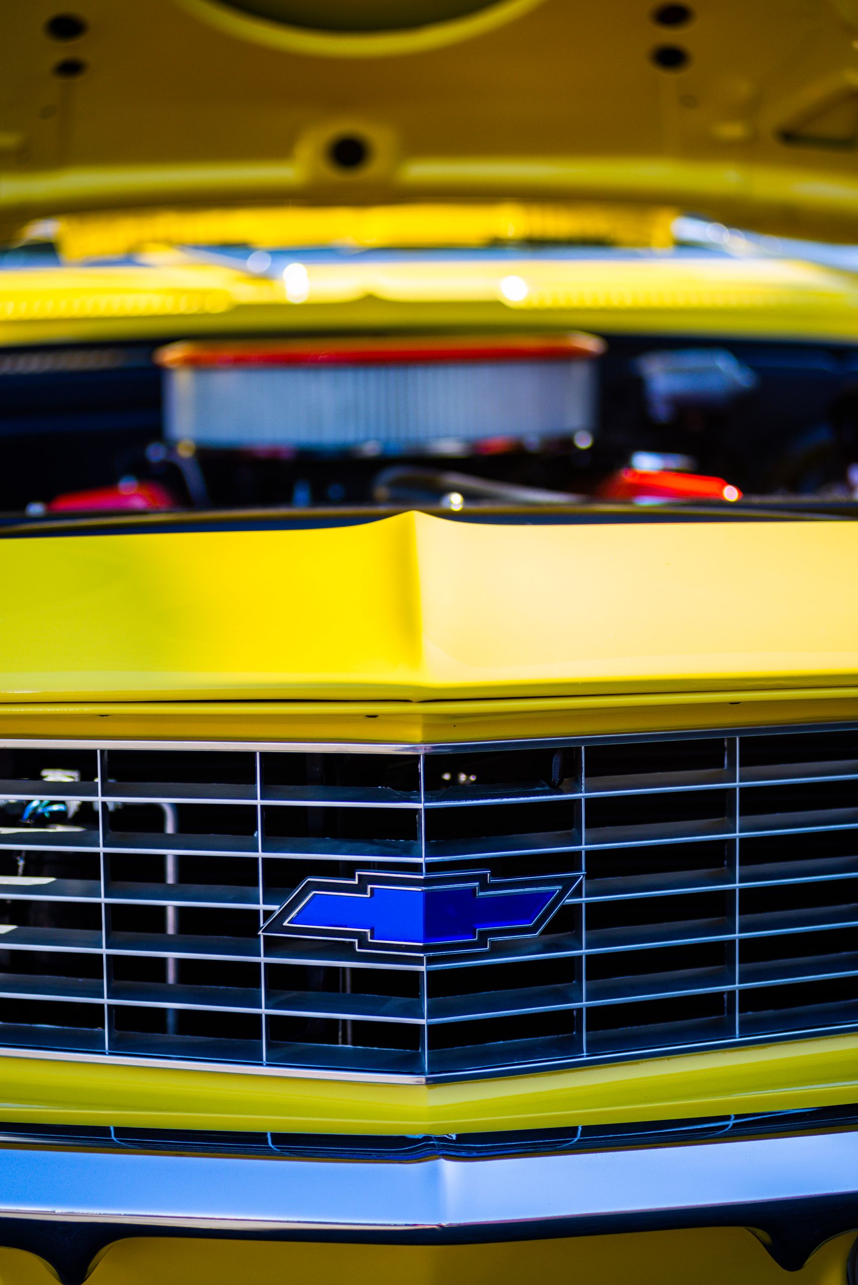Detailed close-up of a classic yellow Chevrolet car grille with emblem.