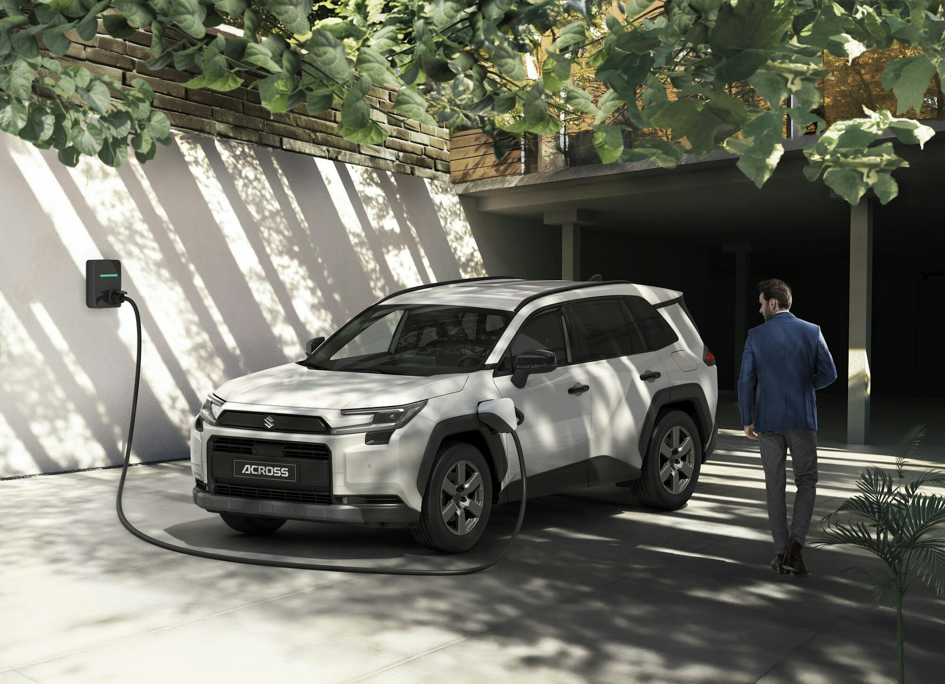 Suzuki ACROSS en recharge devant une maison